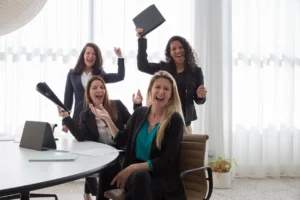 Motivated employees smiling during a small team celebration at work