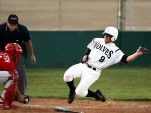 Confident baseball player posing with bat under stadium lights.