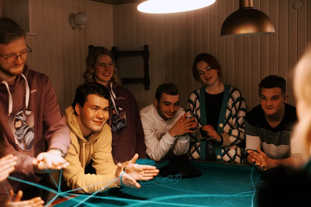 A vibrant, friendly group of people sitting together, laughing and talking, with speech bubbles around them showing question marks.