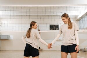 Womenâs volleyball team posing confidently after a match
